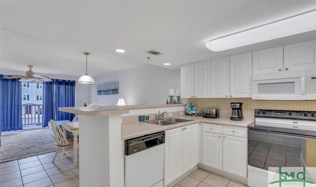 3 3rd St Unit 517, Tybee Island, GA 31328 - kitchen with white appliances, a peninsula, light tile patterned floors, white cabinetry, and light countertops