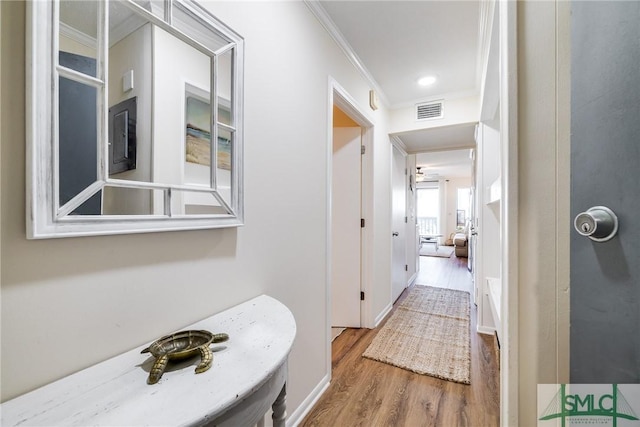 corridor with hardwood / wood-style floors and ornamental molding