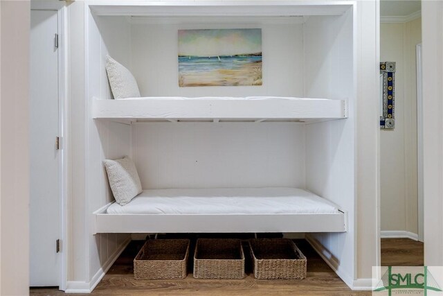 interior details featuring baseboards, crown molding, and wood finished floors