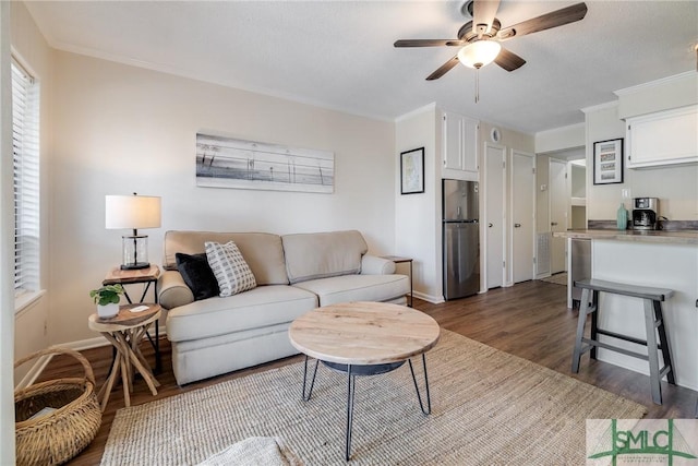 1217 Bay St Unit 105A, Tybee Island, GA 31328 - living area with dark wood-type flooring, ceiling fan, baseboards, and ornamental molding