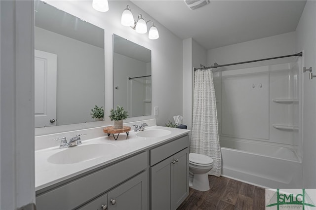 full bathroom featuring wood-type flooring, vanity, shower / tub combo, and toilet