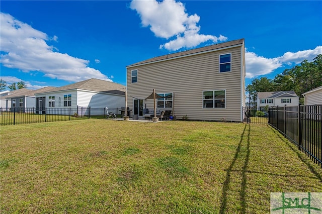 rear view of house featuring a yard and a patio