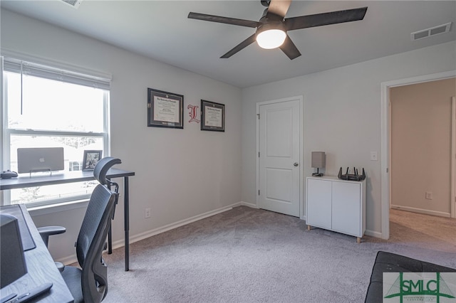 carpeted office space featuring ceiling fan