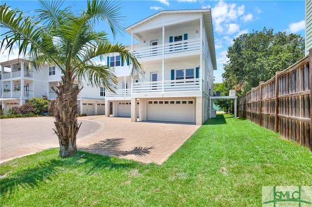 coastal inspired home featuring a front yard and a garage