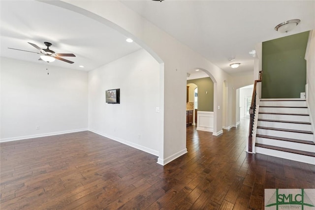 spare room featuring arched walkways, ceiling fan, recessed lighting, dark wood-style flooring, and baseboards