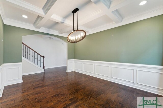 empty room with arched walkways, coffered ceiling, stairs, beam ceiling, and dark wood-style floors