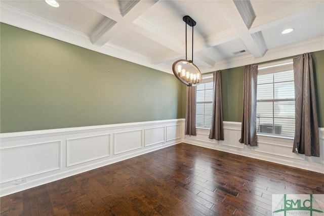 empty room featuring a wainscoted wall, coffered ceiling, beam ceiling, dark wood finished floors, and an inviting chandelier