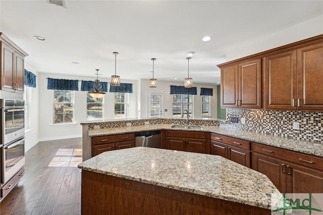 kitchen featuring a healthy amount of sunlight, tasteful backsplash, appliances with stainless steel finishes, and a sink