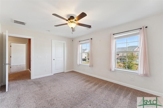 unfurnished bedroom featuring carpet floors, baseboards, visible vents, and ceiling fan