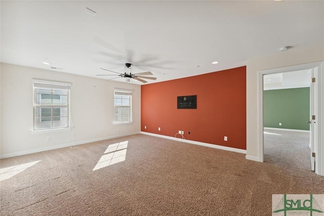 carpeted empty room featuring ceiling fan and baseboards