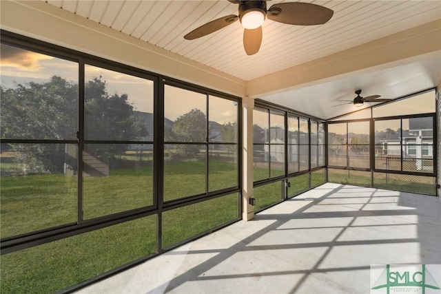 unfurnished sunroom featuring ceiling fan and a wealth of natural light