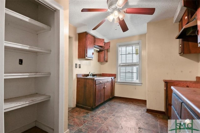 kitchen featuring ceiling fan, sink, and a textured ceiling