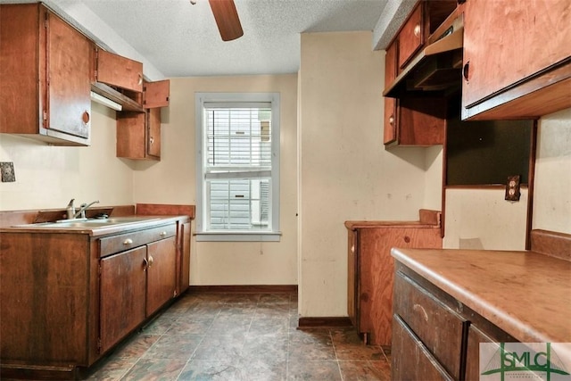 kitchen featuring ceiling fan, sink, extractor fan, and a textured ceiling