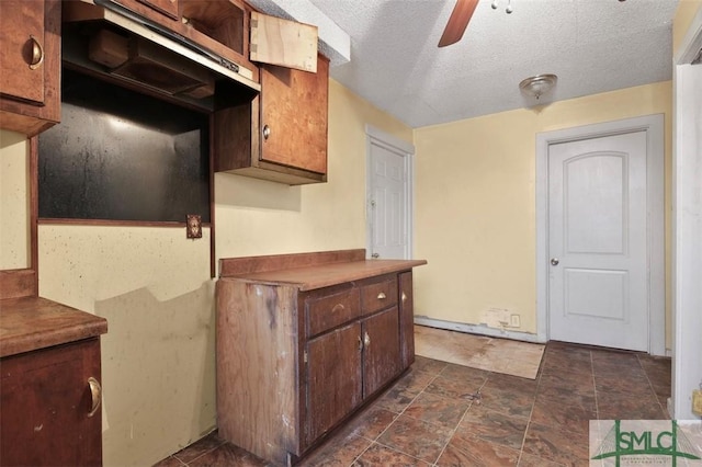 kitchen with ceiling fan and a textured ceiling