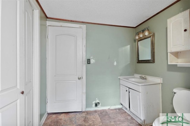 bathroom featuring vanity, ornamental molding, a textured ceiling, and toilet