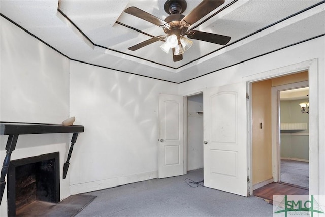 living room with hardwood / wood-style floors, ceiling fan, a fireplace, and a textured ceiling