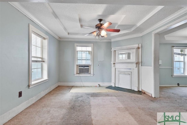 empty room featuring ceiling fan, crown molding, light carpet, and a tray ceiling