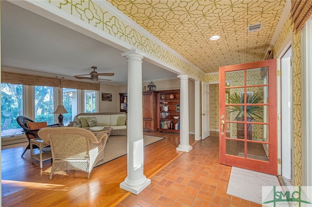 living room with hardwood / wood-style flooring, ceiling fan, and ornamental molding