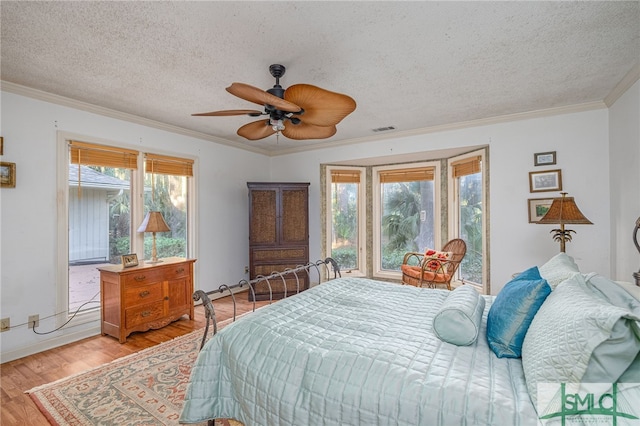 bedroom with multiple windows, ceiling fan, light hardwood / wood-style floors, and a textured ceiling