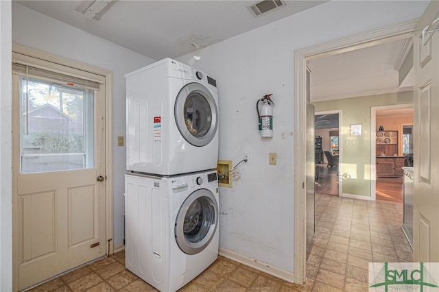 laundry room with stacked washing maching and dryer