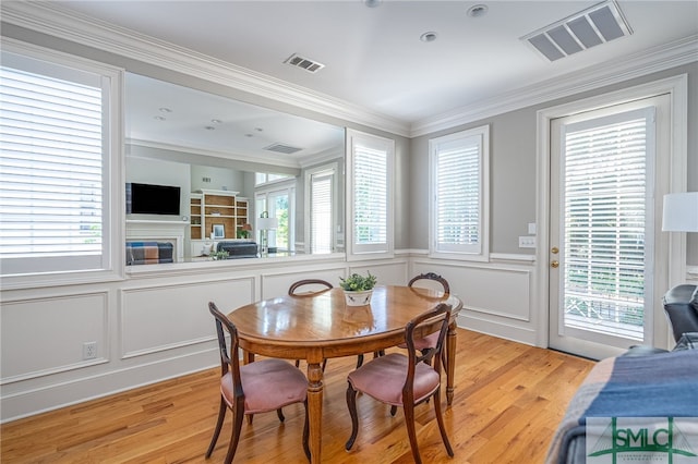 dining room with plenty of natural light, light hardwood / wood-style floors, and ornamental molding