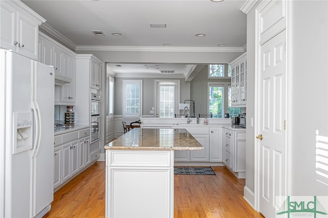 kitchen featuring a center island, light hardwood / wood-style floors, white cabinetry, and white fridge with ice dispenser