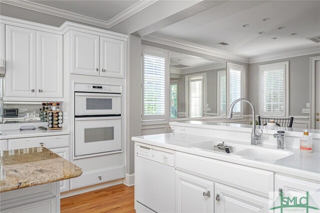 kitchen featuring white cabinets, white appliances, sink, and light hardwood / wood-style flooring