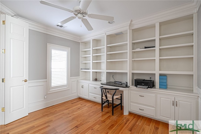 home office featuring built in shelves, light hardwood / wood-style flooring, ceiling fan, and ornamental molding