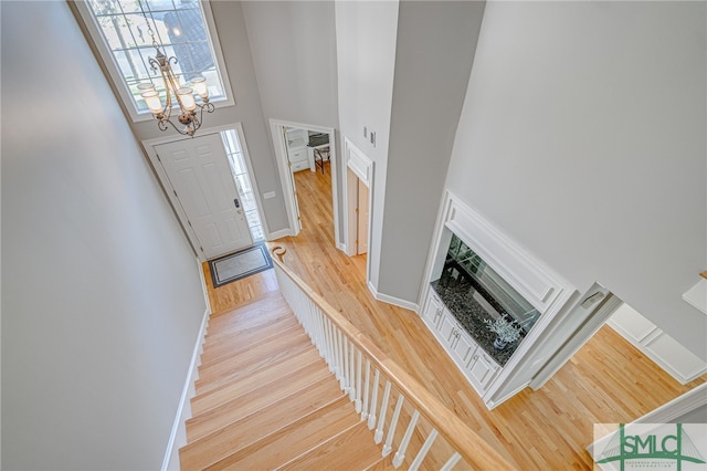 entryway featuring a high ceiling, hardwood / wood-style flooring, and a notable chandelier