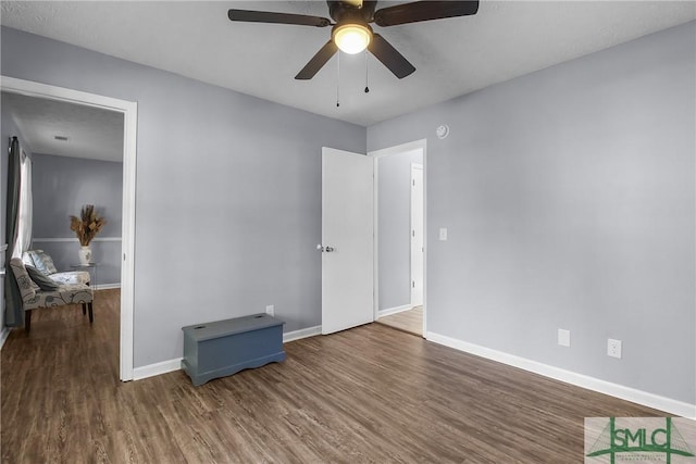 bedroom with wood finished floors, a ceiling fan, and baseboards