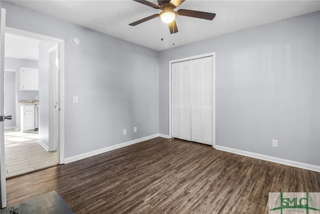 unfurnished bedroom with ceiling fan, dark hardwood / wood-style flooring, and a closet