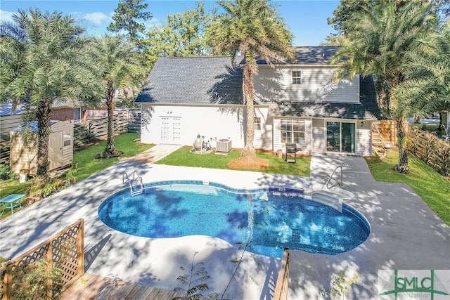 view of pool featuring central AC, a patio, and a lawn