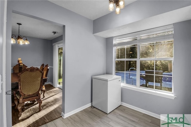 interior space with light hardwood / wood-style floors and a notable chandelier