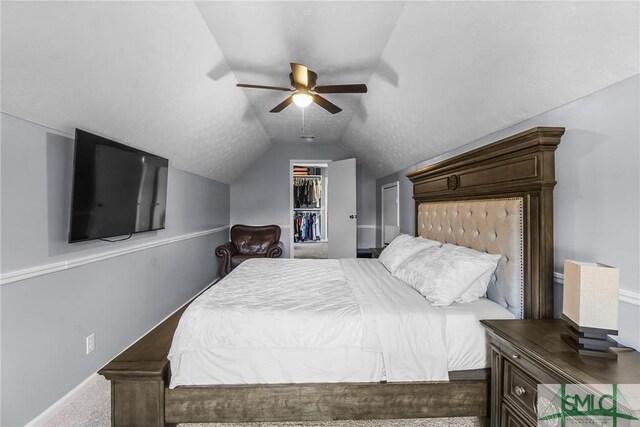 bedroom with lofted ceiling, a ceiling fan, a spacious closet, a closet, and carpet