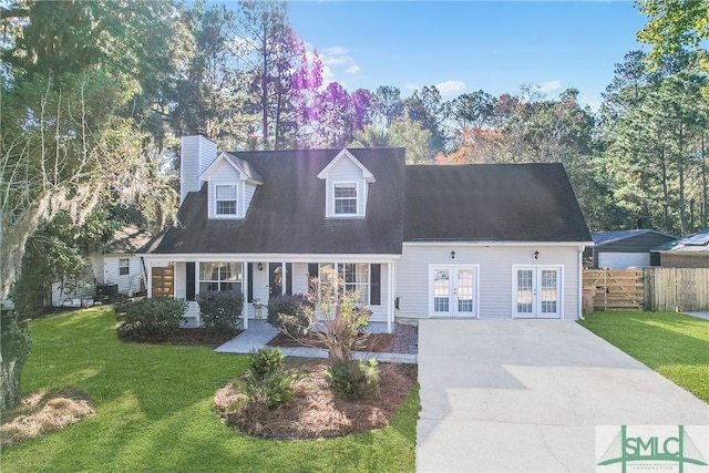 cape cod-style house featuring a front yard, french doors, fence, and a chimney