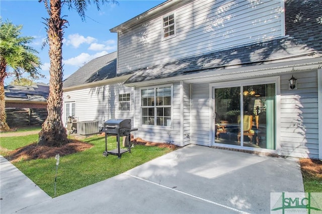 rear view of house featuring a yard, cooling unit, and a patio area