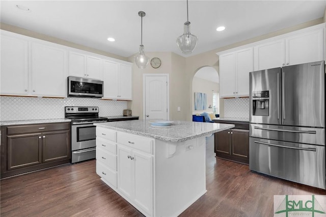 kitchen with appliances with stainless steel finishes, white cabinetry, and dark wood-type flooring