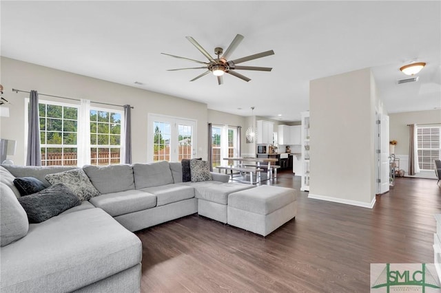 living room with ceiling fan and dark wood-type flooring