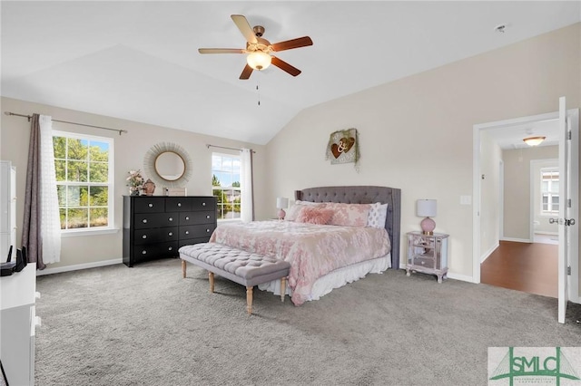 carpeted bedroom featuring vaulted ceiling, multiple windows, and ceiling fan