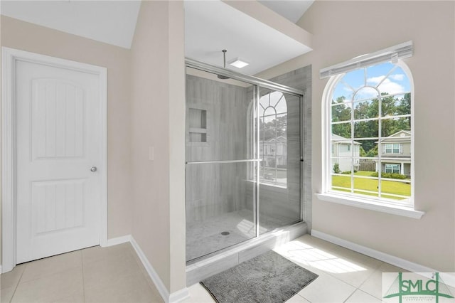 bathroom featuring tile patterned floors, a shower with shower door, and lofted ceiling