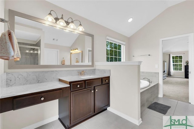 bathroom with plus walk in shower, vanity, tile patterned floors, and lofted ceiling