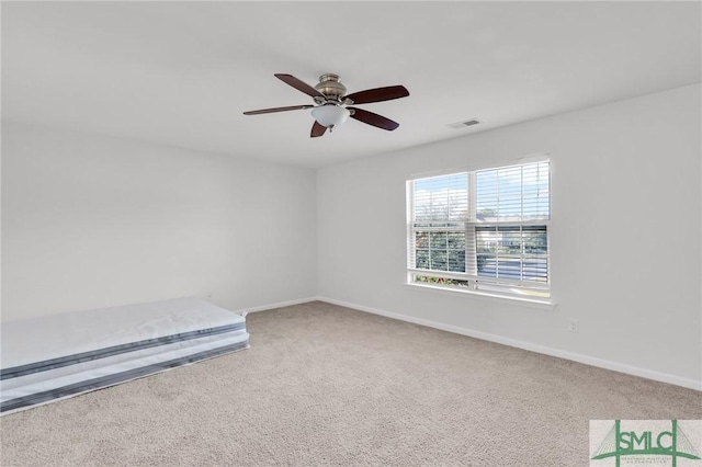 carpeted empty room featuring ceiling fan