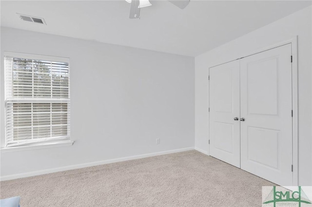 unfurnished bedroom with a closet, ceiling fan, and light colored carpet