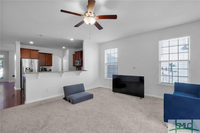 living room with ceiling fan and light carpet