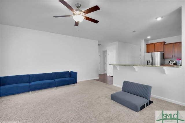 carpeted living room with ceiling fan