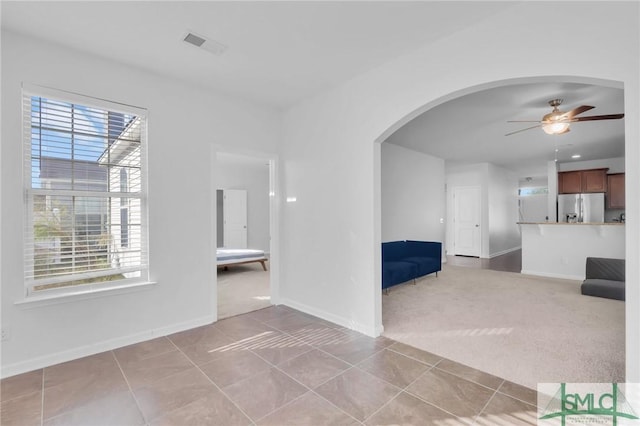 interior space featuring light carpet and ceiling fan