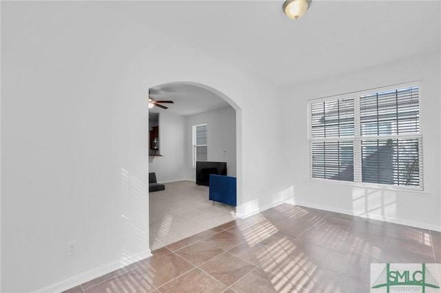 empty room featuring light carpet, ceiling fan, and a fireplace