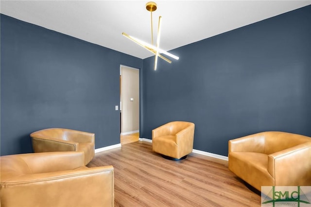 living area featuring a notable chandelier and light wood-type flooring