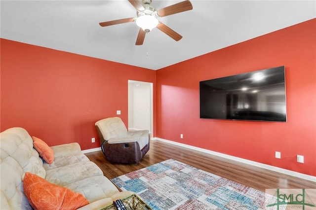 living room featuring ceiling fan and dark wood-type flooring