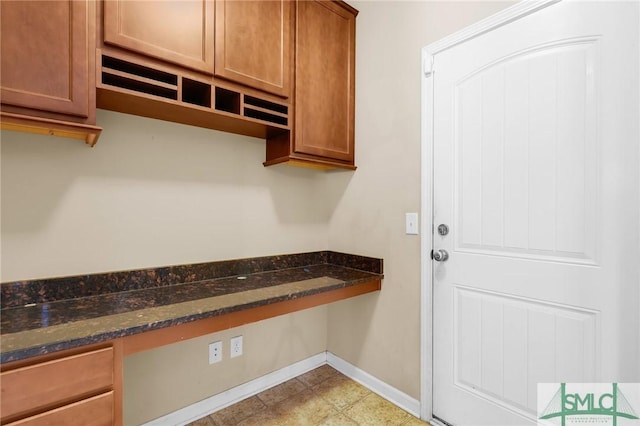 kitchen with dark stone countertops and built in desk